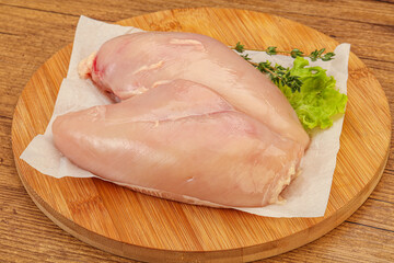 Raw chicken breast over board