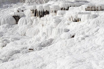 Fototapeta na wymiar Close up of white limestone natural travertine terraces in pamukkale with pools full of carbonated water