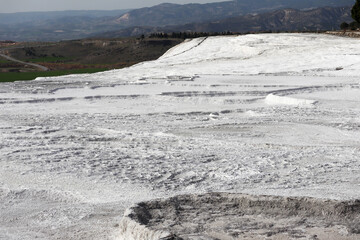 beautiful white fields of carbonated limestone formations in Pamukkale, Turkey