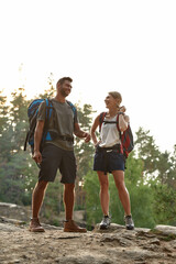 Laughing young caucasian couple standing on rock