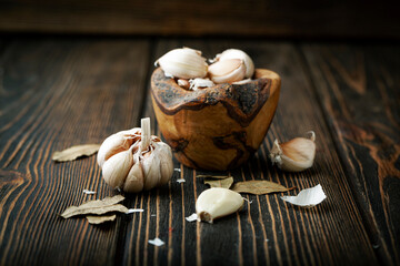 Garlic in a bowl on a wood background - 436391636