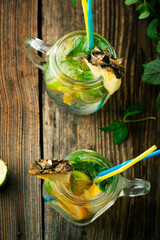 Lemonade with lime mint and pineapple on wooden background - 436391698