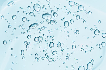 Fototapeta na wymiar Close up macro Aloe vera gel cosmetic texture blue background with bubbles. Lemongrass gel skincare product. antibacterial liquid with aloe vera, moisturizing. Safe and environmental friendly.