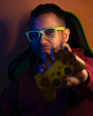 Portrait of Latino man wearing big green glasses, illuminated with RGB led lights. Hispanic with a...