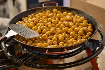 Blurred image of young potatoes cooking in a large skillet.Street food concept.