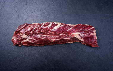 Raw wagyu onglet beef steak offered as top view on a black board with copy space