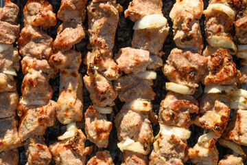Marinated meat pork preparing on a barbecue grill over charcoal. BBQ party. Food pattern. Top view.