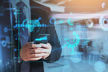 Businessman wearing black suit is holding a smartphone and chatting using social network. Digital device helps people to cooperate and communicate all over the world