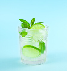 Mojito in a glass beaker on a blue background.