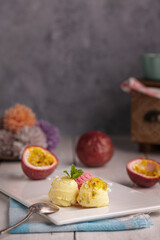 Scoops of passion, vanilla and strawberry ice cream on a white plate