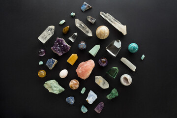 Flat lay of various crystal stones set on black background. Gemstones on dark background. Colorful...