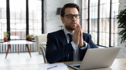 Tranquil calm businessman practicing concentration and mindfulness, meditating and relaxing at...