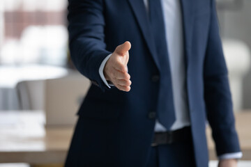 Businessman in formal suit offering handshake. Business leader giving hand for shake. Recruiter inviting for job interview and hiring. Manager offering consultation to client or customer. Close up