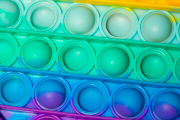 Close up view of the sensory toy pop it with Rainbow color.