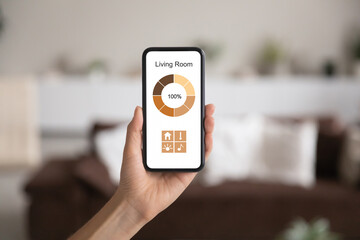 Crop close up of woman hold modern cellphone gadget with smart home application on screen. Female renter use smarthome system on smartphone device with control panel. Technology concept.