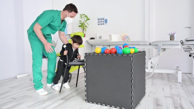 Child with cerebral palsy on physiotherapy in a children therapy center. Boy with disability doing exercises with physiotherapists in rehabilitation centre. High quality 4k footage