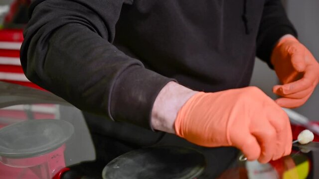 Close up of Automobile technician worker replacing windscreen of a car in automobile service station garage. High quality 4k footage