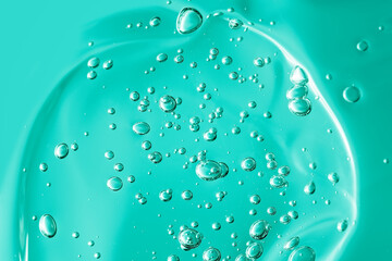 Close up macro Aloe vera gel cosmetic texture blue background with bubbles.