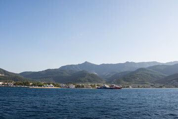 Fototapeta na wymiar Island Thassos, Greece - Two ferries docked in the port of Island Thasos, ferryboat transportation, Greek hills, mountains, harbor