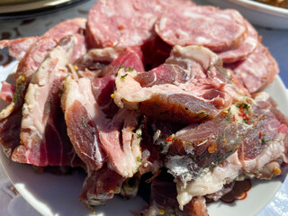 A plate with delicious red smoked meat, ham, bacon, lard, sausage and pork neck