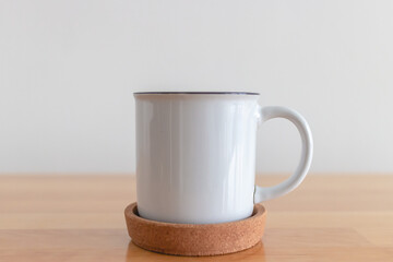 White cup of hot coffee mug on wooden table with isolate white background.