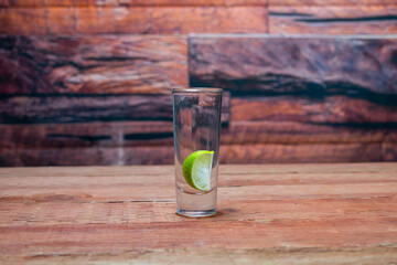 shot of tequila with a lemon slice inside in a Mexican bar
