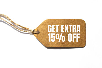 GET EXTRA 15 OFF percent text on a brown tag on a white paper background