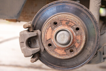 Old car brake disc. The brakes on the car require regular maintenance. Very close-up of the brake disc and pads when replacing the wheel.