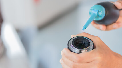 A man who cleans the lens and blows it with a rubber ball.