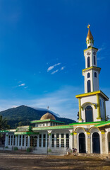 Beautiful mosque under the blue sky with mountains in the background