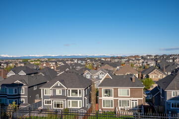 Roof top view of modern suburban home in Calgary with mountain in the background. 