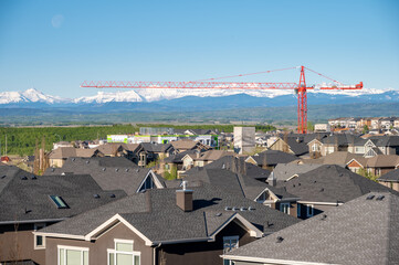 Roof top view of modern suburban home in Calgary with mountain in the background. 