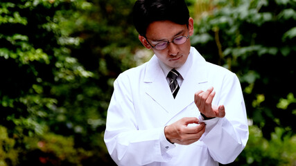 袖を直す白衣を着た男性医師