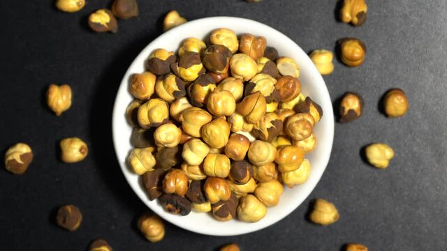 Top view of roasted chickepas or bhuna chana on dark background 