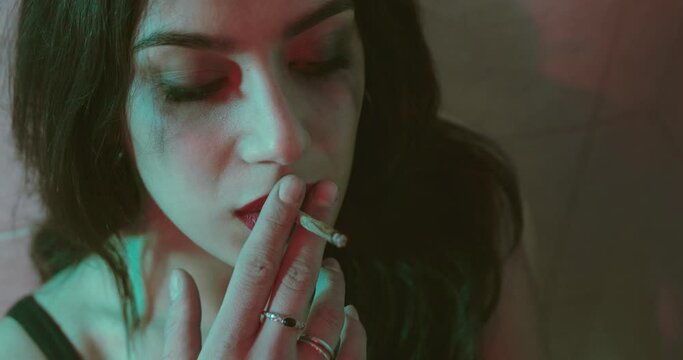 high on drugs - depressed girl eagerly smokes a joint of marijuana
