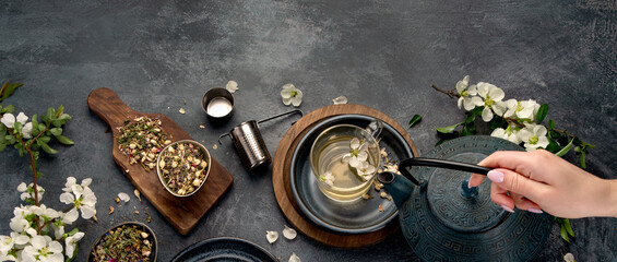 Green herbal tea with cups and teapot on gray backround.