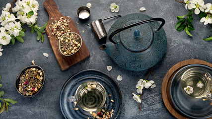 Fototapeta na wymiar Green herbal tea with cups and teapot on gray backround.
