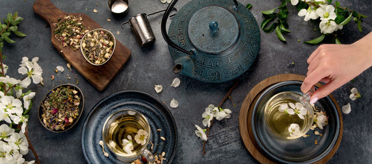 Fototapeta na wymiar Green herbal tea with cups and teapot on gray backround.