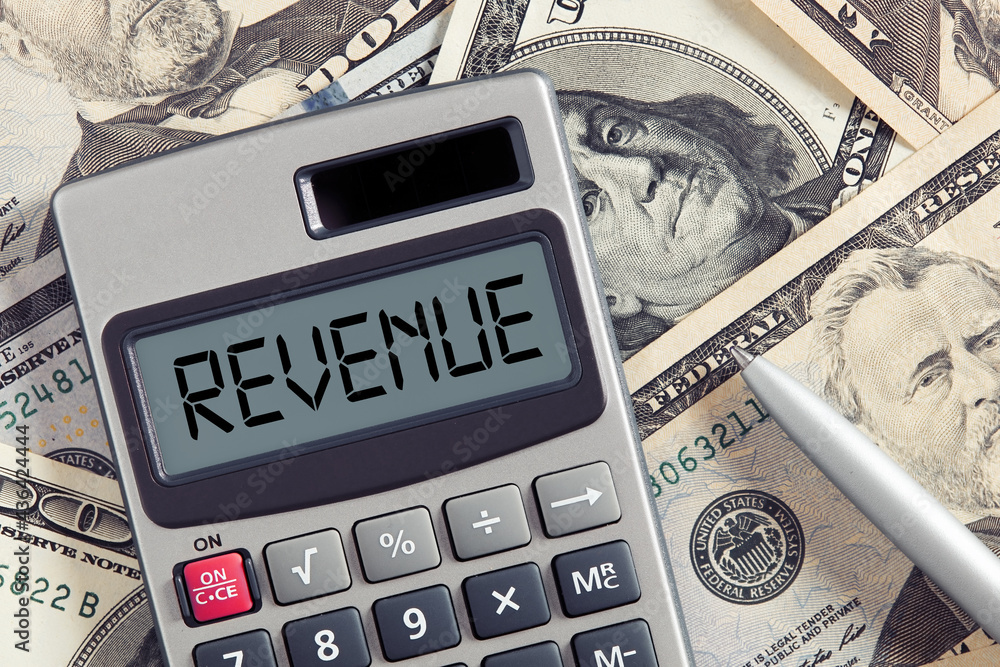 Poster the word revenue on calculator display with dollar bills background. to calculate or increase revenu