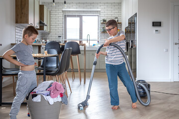 Two little boys help with the laundry and cleaning of the house.