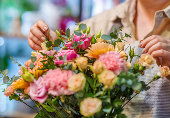 Close-up image of florist's hands correcting a bouquet in a flower shop
