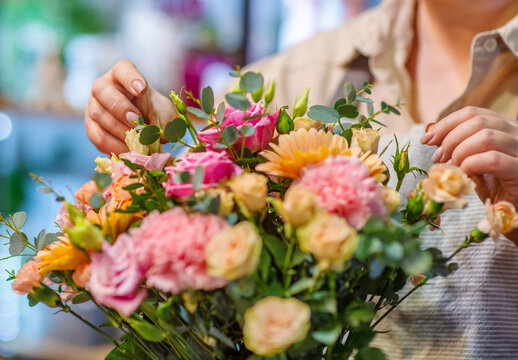 Close-up image of florist's hands correcting a bouquet in a flower shop