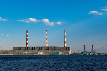 Hydroelectric power station operates and produces energy and electricity on shore of a reservoir in city