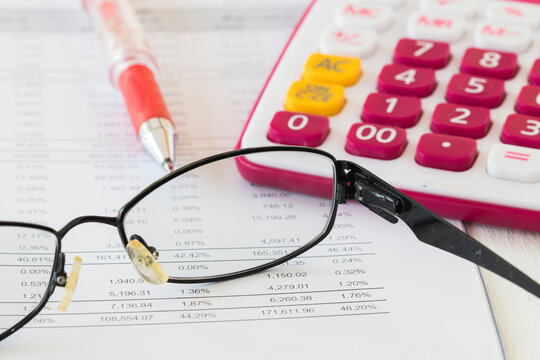 financial statement yearly with calculator, sunglasses for business arrangement flat lay style at office desk