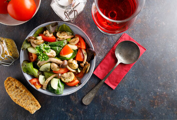 mushroom salad in a bowl. Summer meal a salad with himeji, oyster fungus, white Paris mushrooms mixed with young lettuce, tomatoes and cucumber.