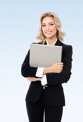 Portrait of young happy smiling businesswoman with grey folder, with blank copyspace area for slogan or text, on blue background. Success in business, job and education concept.