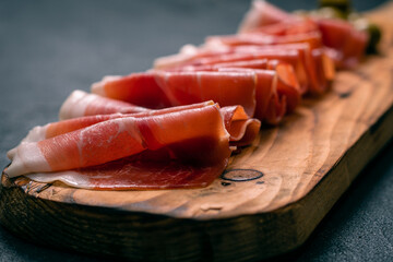 raw ham feta on wooden board