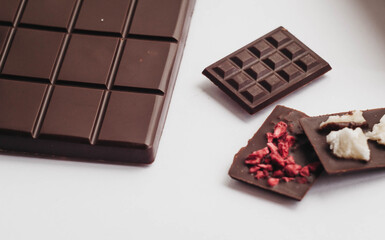 Milk chocolate pieces isolated on white background from top view