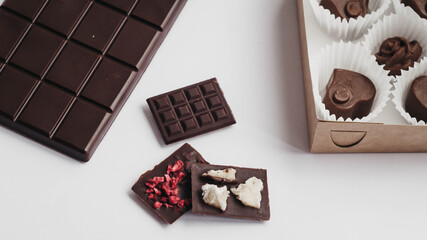 Milk chocolate pieces isolated on white background from top view