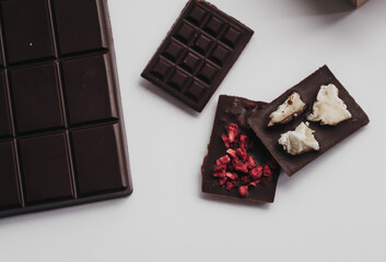 Milk chocolate pieces isolated on white background from top view